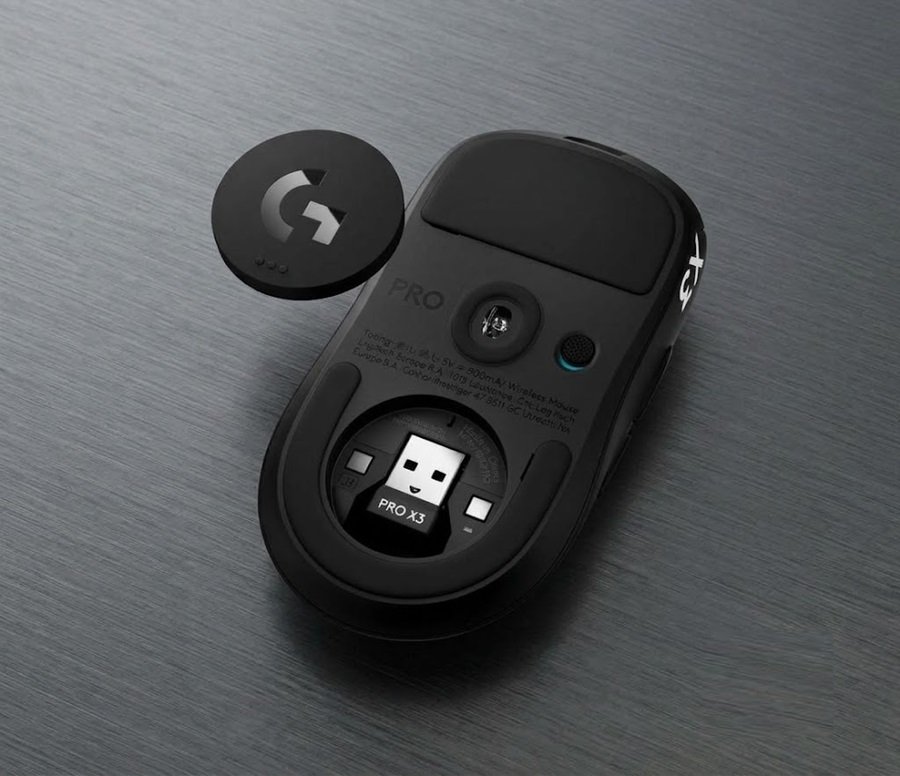 Underside of the Logitech PRO X3 SUPERSTRIKE with the PowerPlay charging puck removed, revealing the USB receiver storage slot