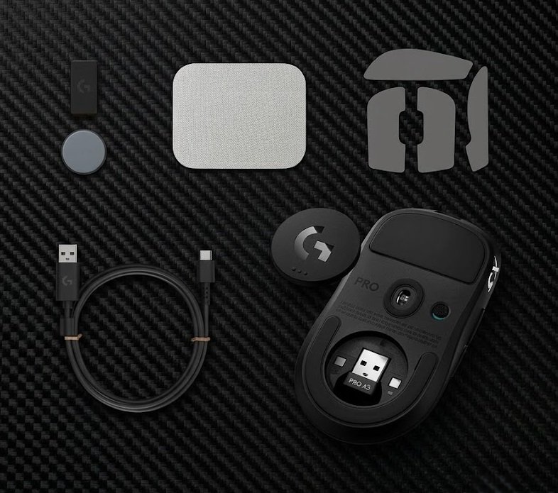 Logitech PRO X3 SUPERSTRIKE unboxing flat-lay showing the mouse, USB-C cable, PowerPlay puck, grip tape, and spare skates